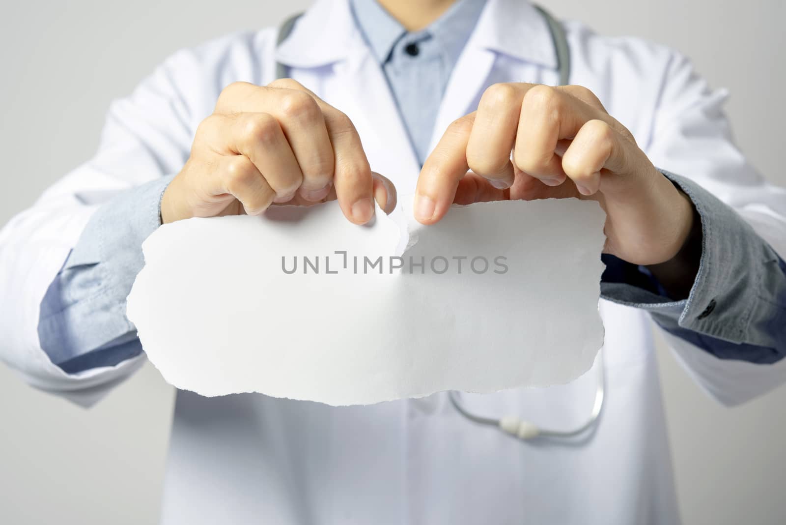 doctor holding label paper mockup with the text on gray wall background.