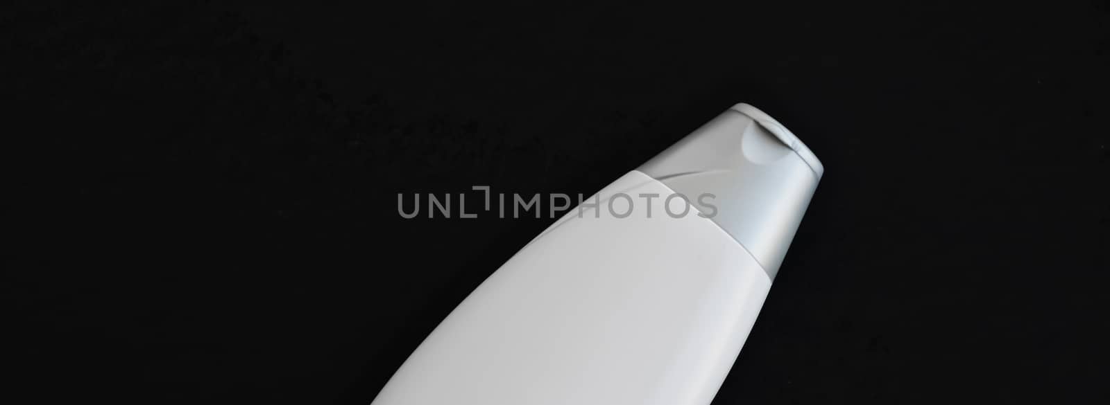 Blank label cosmetic container bottle as product mockup on black background, hygiene and healthcare