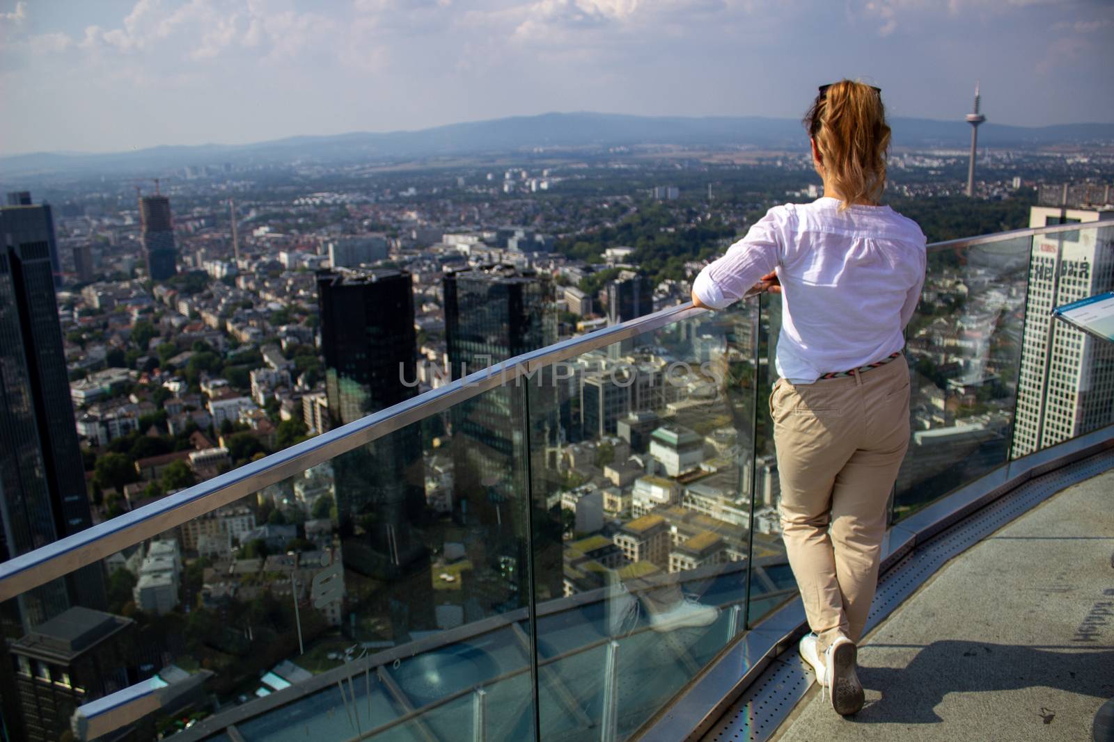 Young tourist girl with looking at the Frankfurt from the top of by AnatoliiFoto