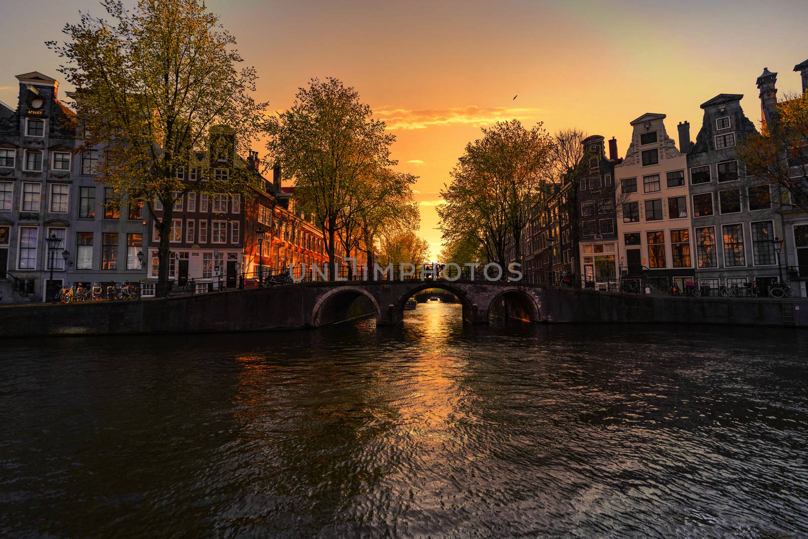 Sunset on the Amsterdam houses and canal reflected on the water of the canal, Amsterdam, Netherlands by ankorlight