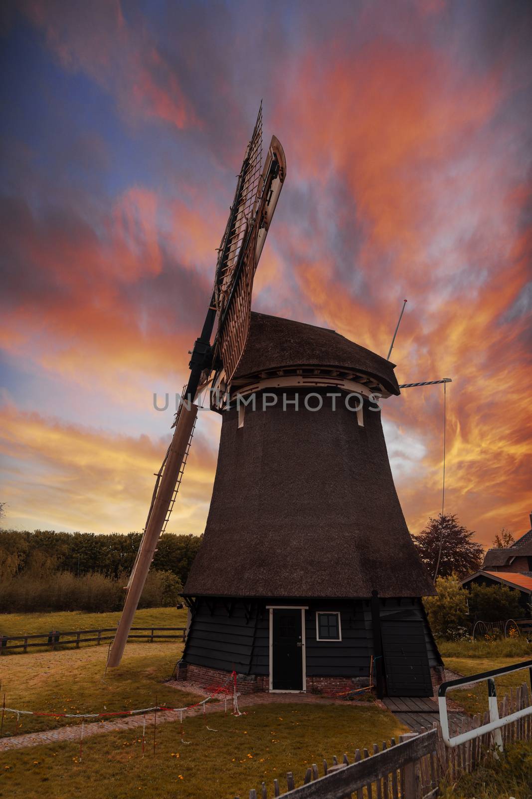 Vivid red and orange color sunset over a Dutch windmill 