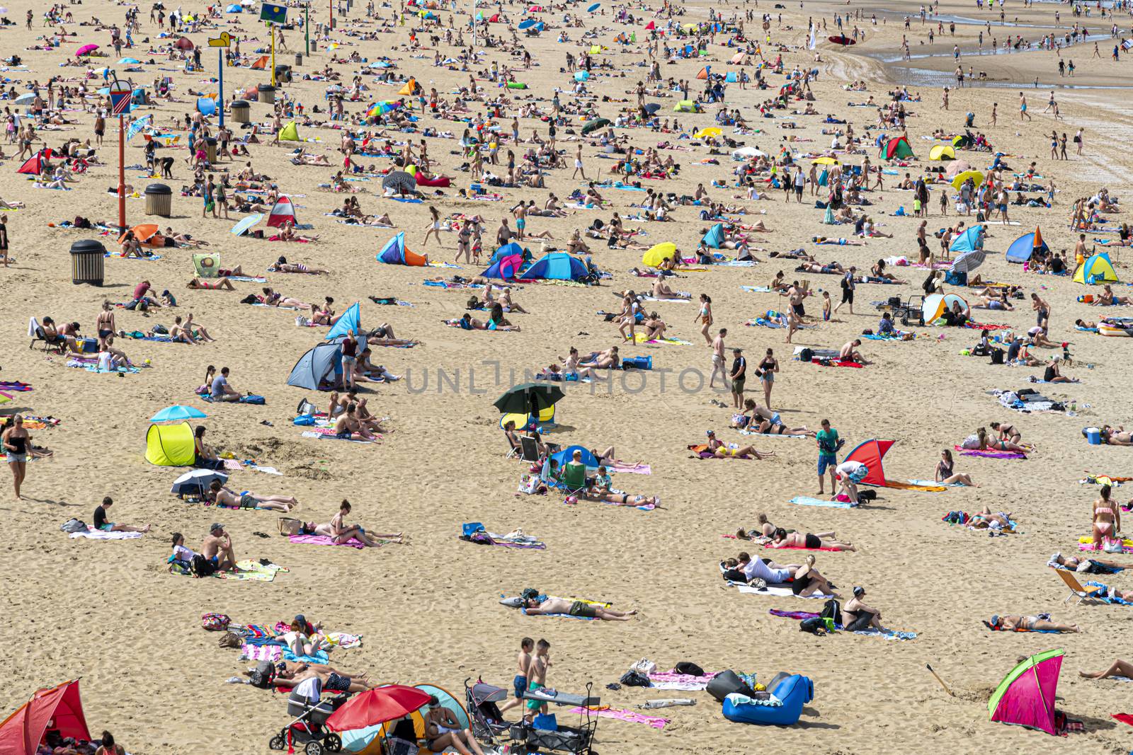 Aerial view of the beach of The Hague with crowded people enjoying take sun bath during the hot and sunny day before the summer.