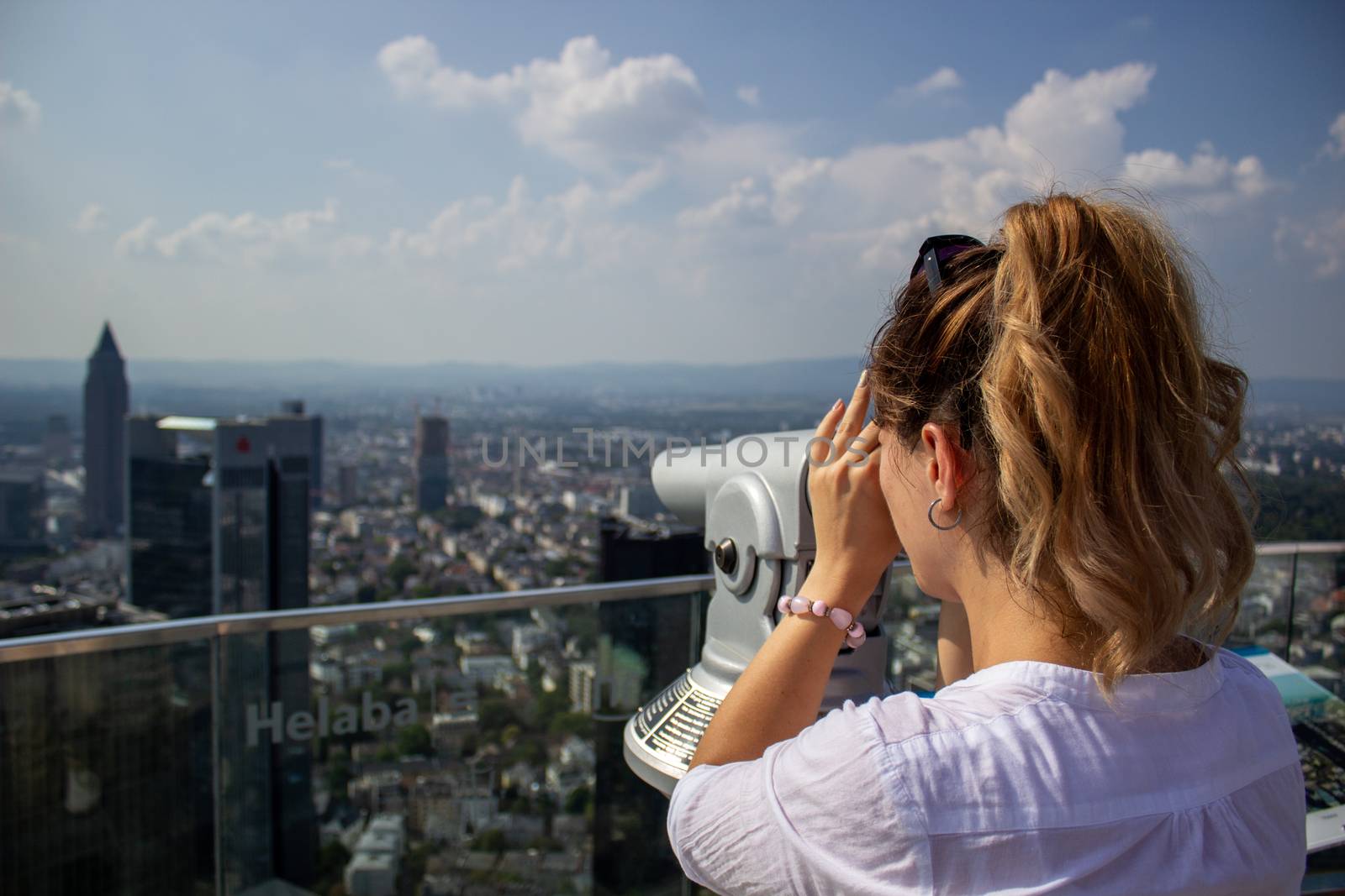 Young tourist girl with looking at the Frankfurt from the top of the main tower. Aerial View Frankfurt am Main from main tower to financial center. by AnatoliiFoto