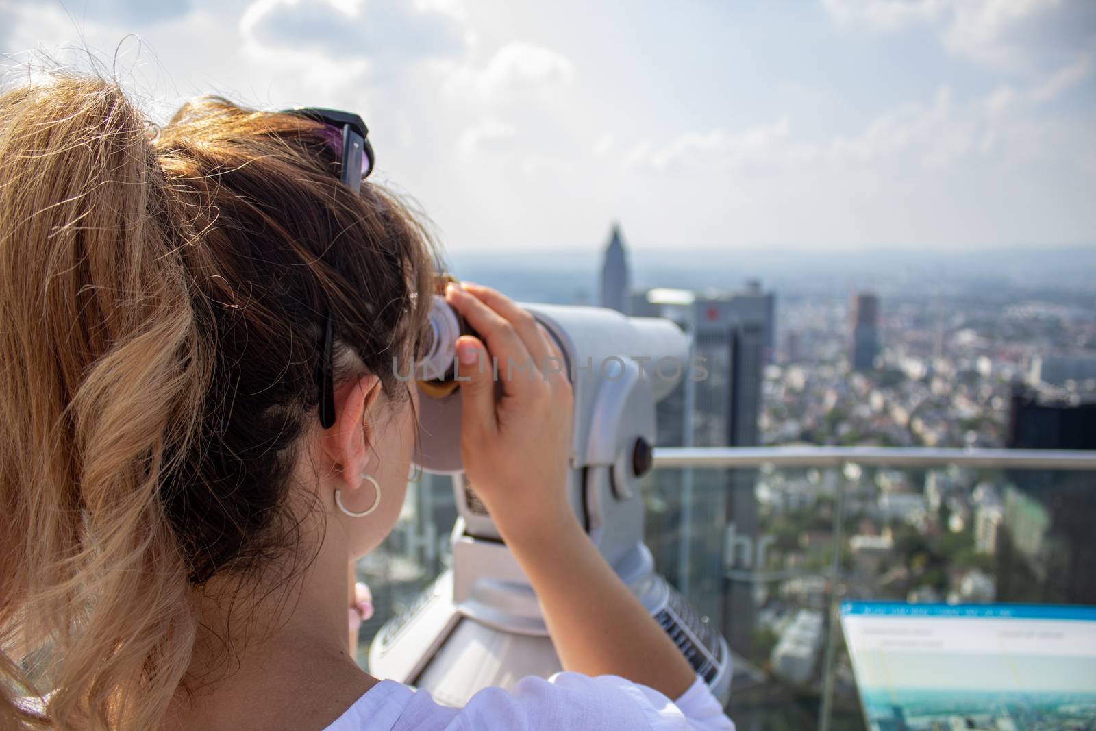 Young tourist girl with looking at the Frankfurt from the top of the main tower. Aerial View Frankfurt am Main from main tower to financial center. by AnatoliiFoto