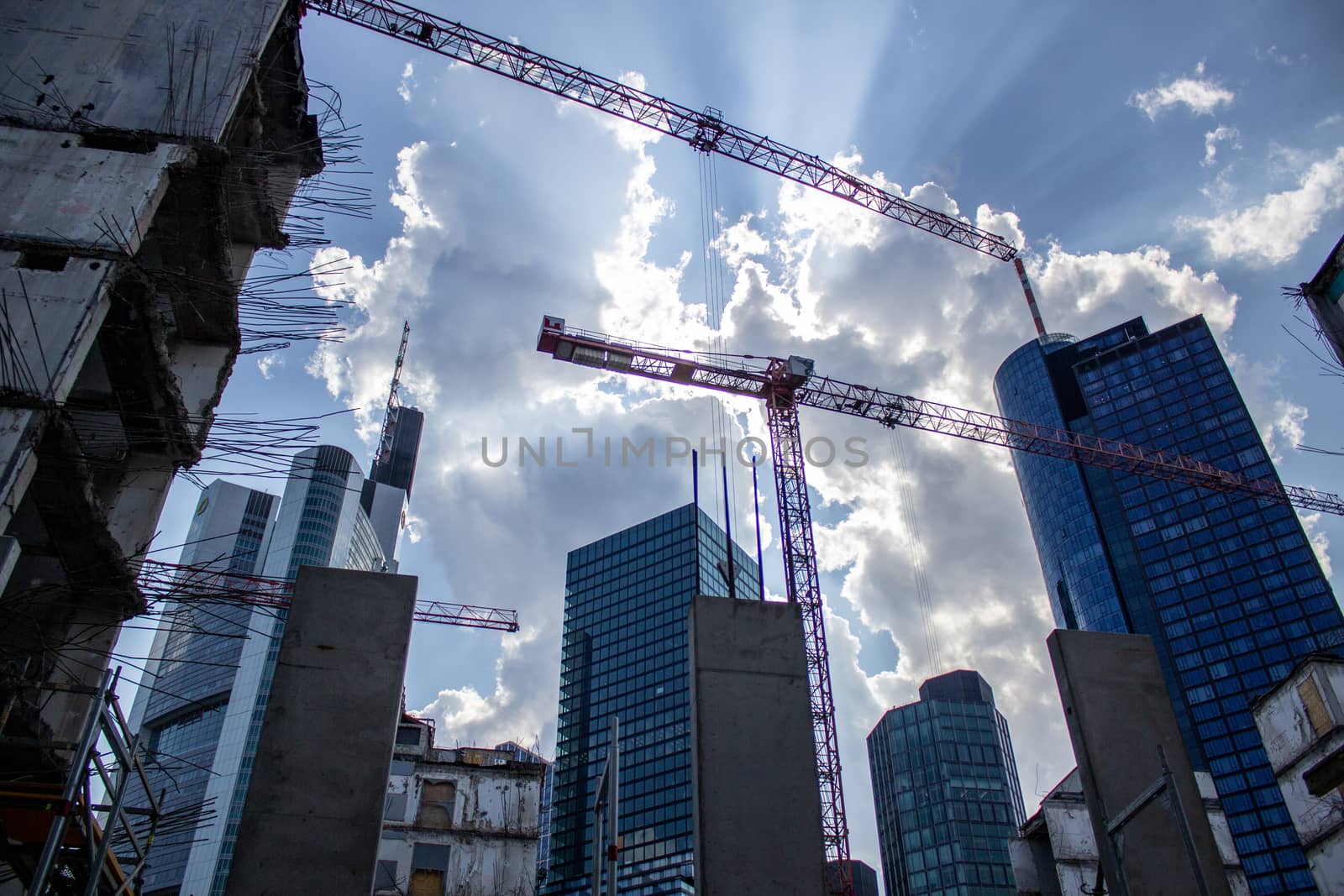 Construction of high-rise buildings in the city. Construction site next to a modern office and residential building. The crane works. Industrial background.