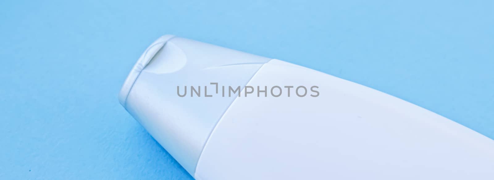 Blank label cosmetic container bottle as product mockup on blue background, hygiene and healthcare