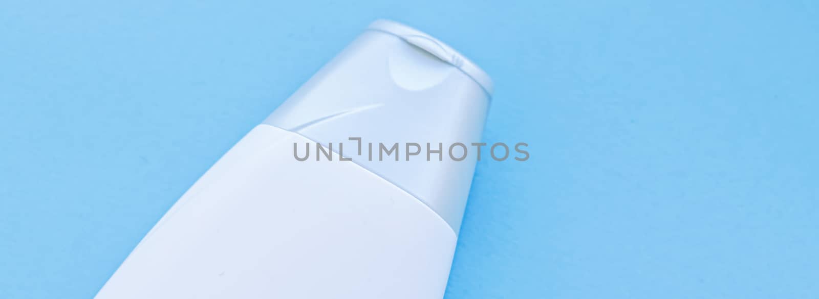 Blank label cosmetic container bottle as product mockup on blue background, hygiene and healthcare