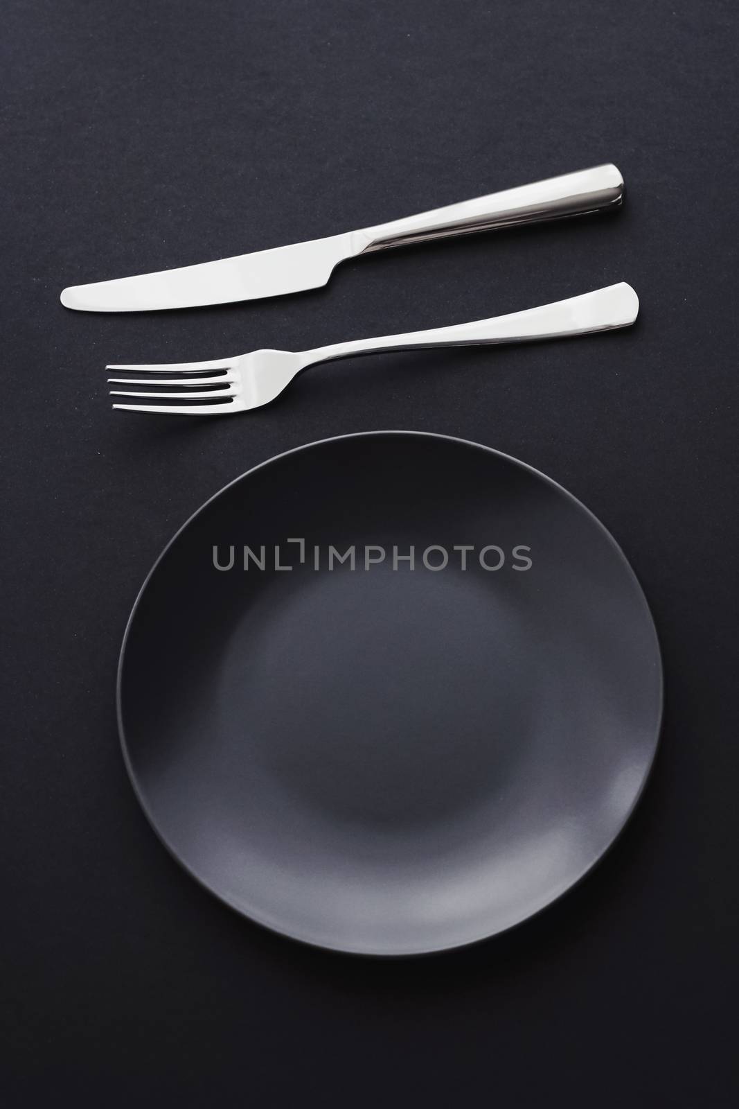 Empty plates and silverware on black background, premium tableware for holiday dinner, minimalistic design and diet concept