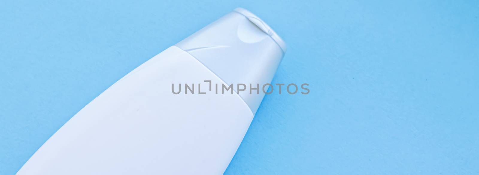 Blank label cosmetic container bottle as product mockup on blue background, hygiene and healthcare