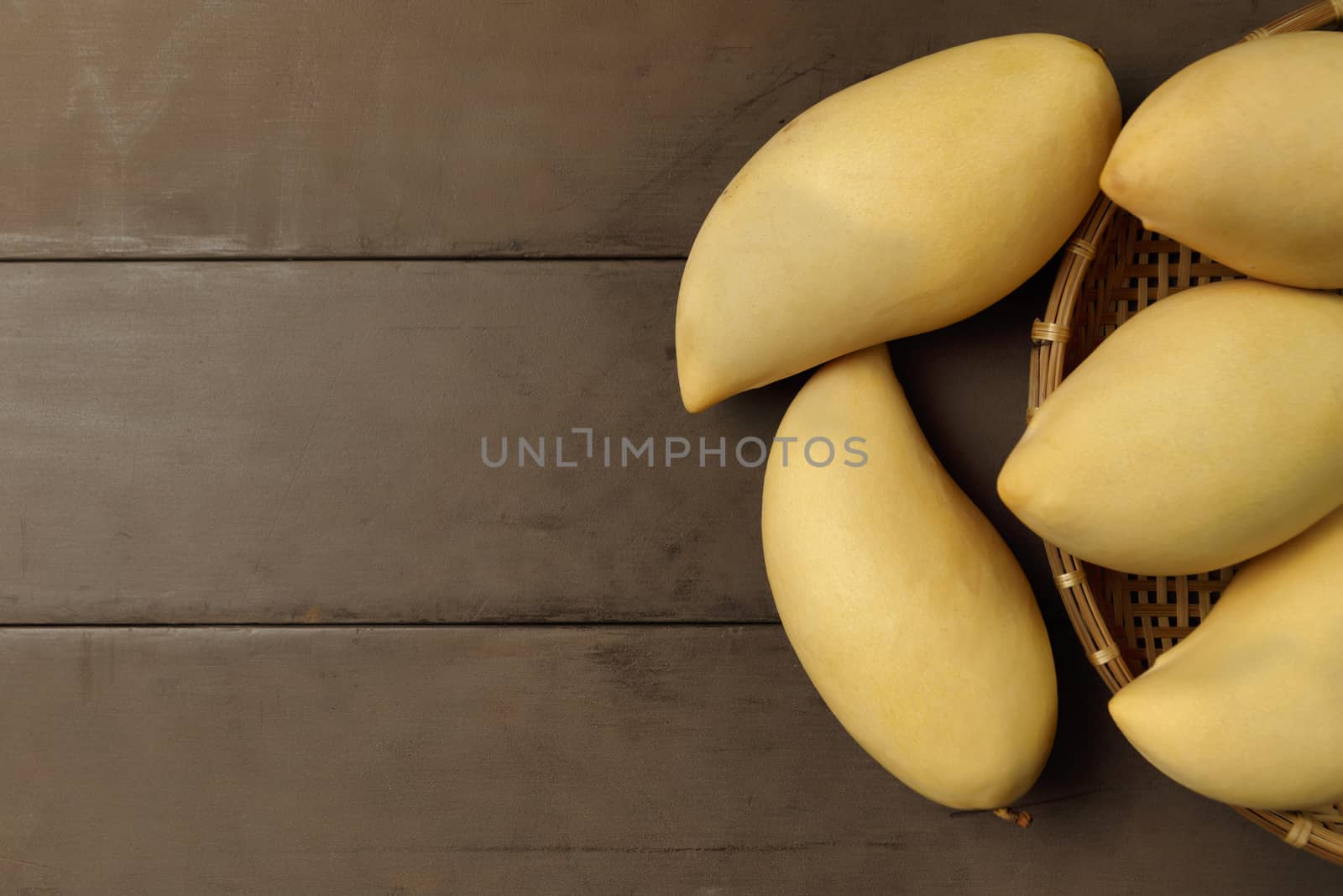 Top view Yellow Fresh mangos on real wood table. Mango tropical fruit on wood background. mangos with copy space.