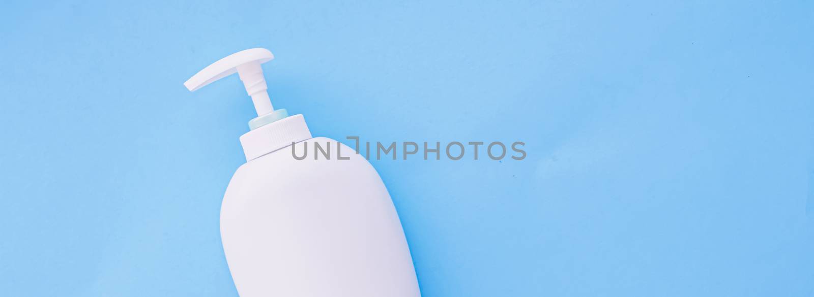 Blank label cosmetic container bottle as product mockup on blue background by Anneleven