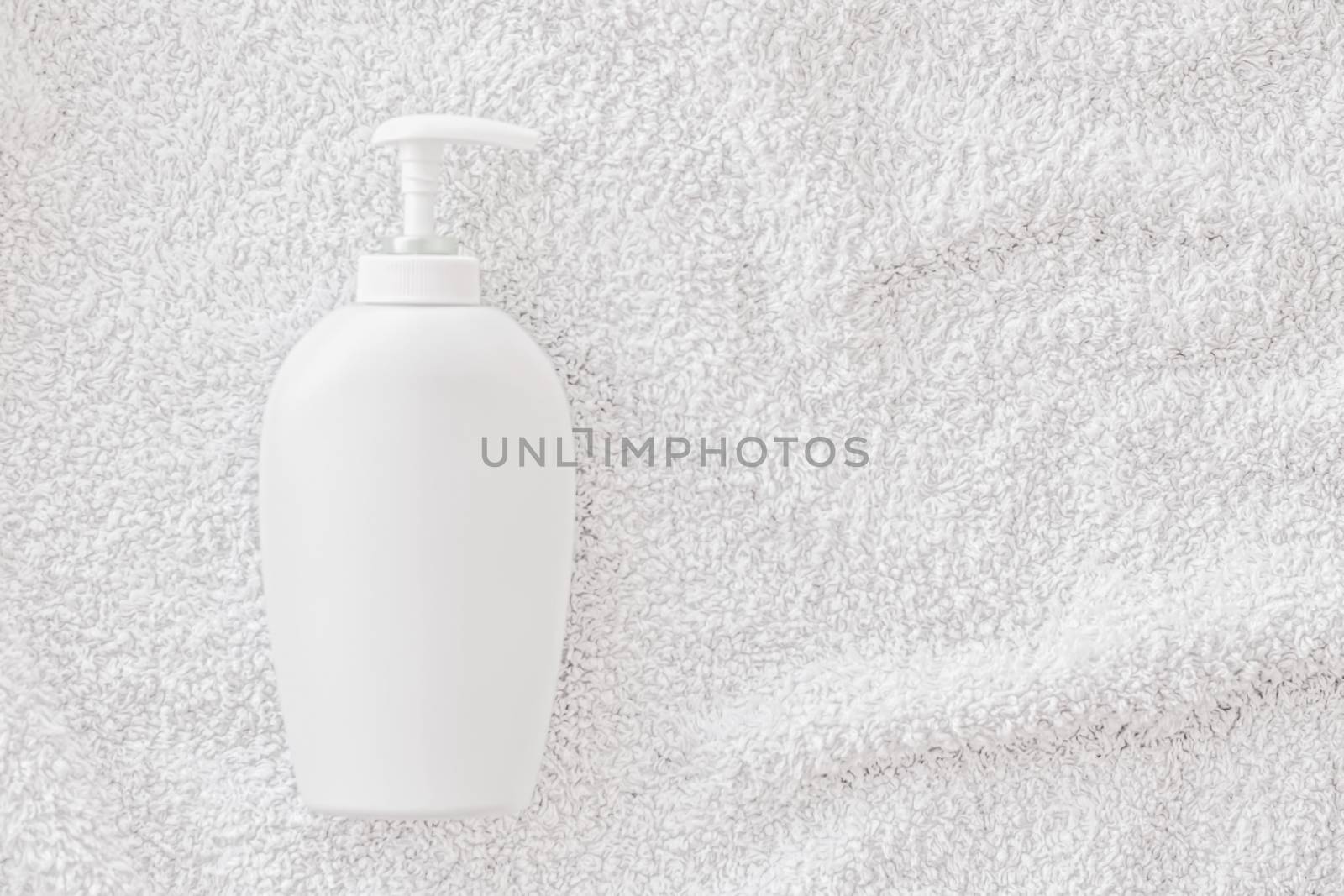 Blank label cosmetic container bottle as product mockup on white towel background by Anneleven