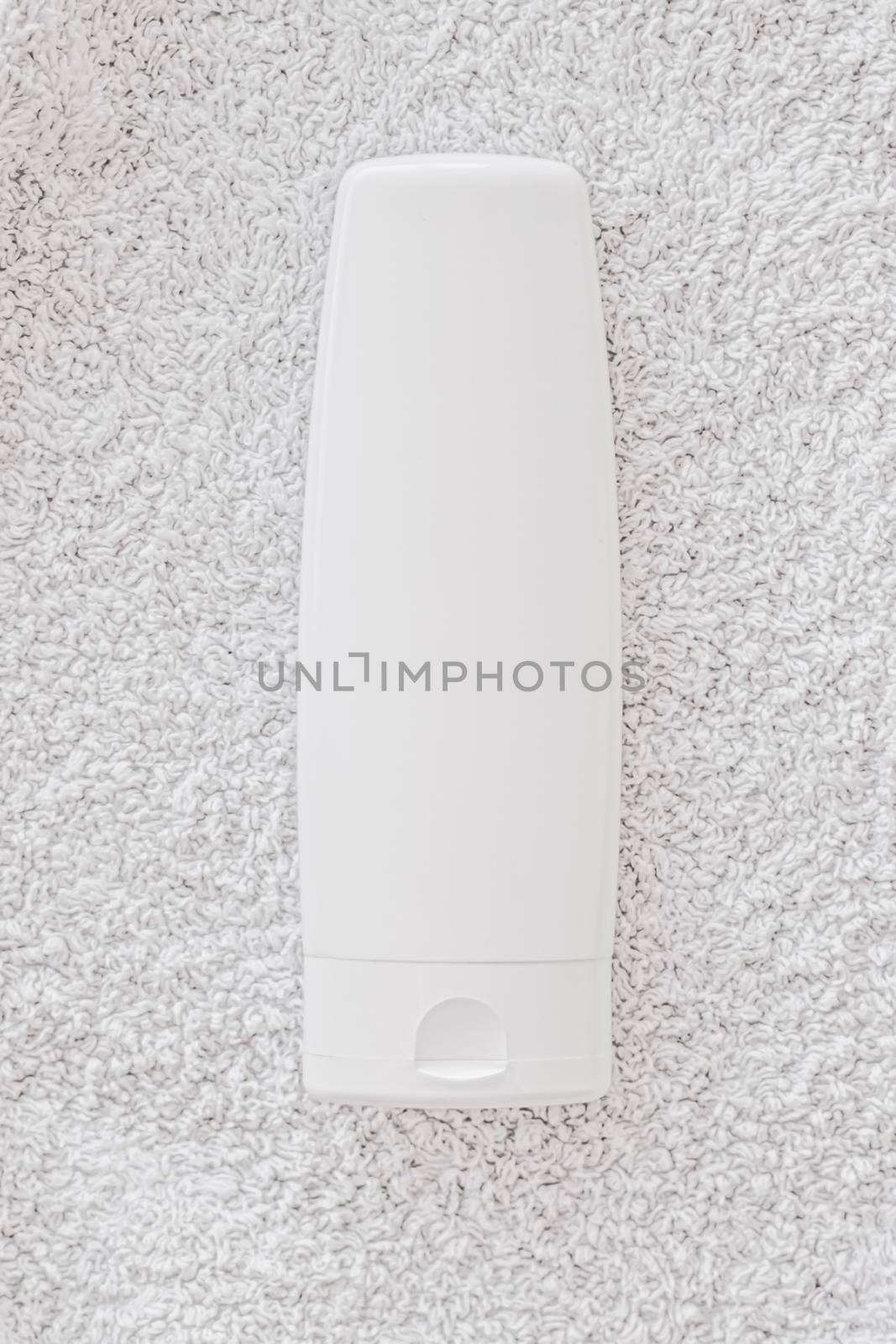 Blank label cosmetic container bottle as product mockup on white towel background by Anneleven