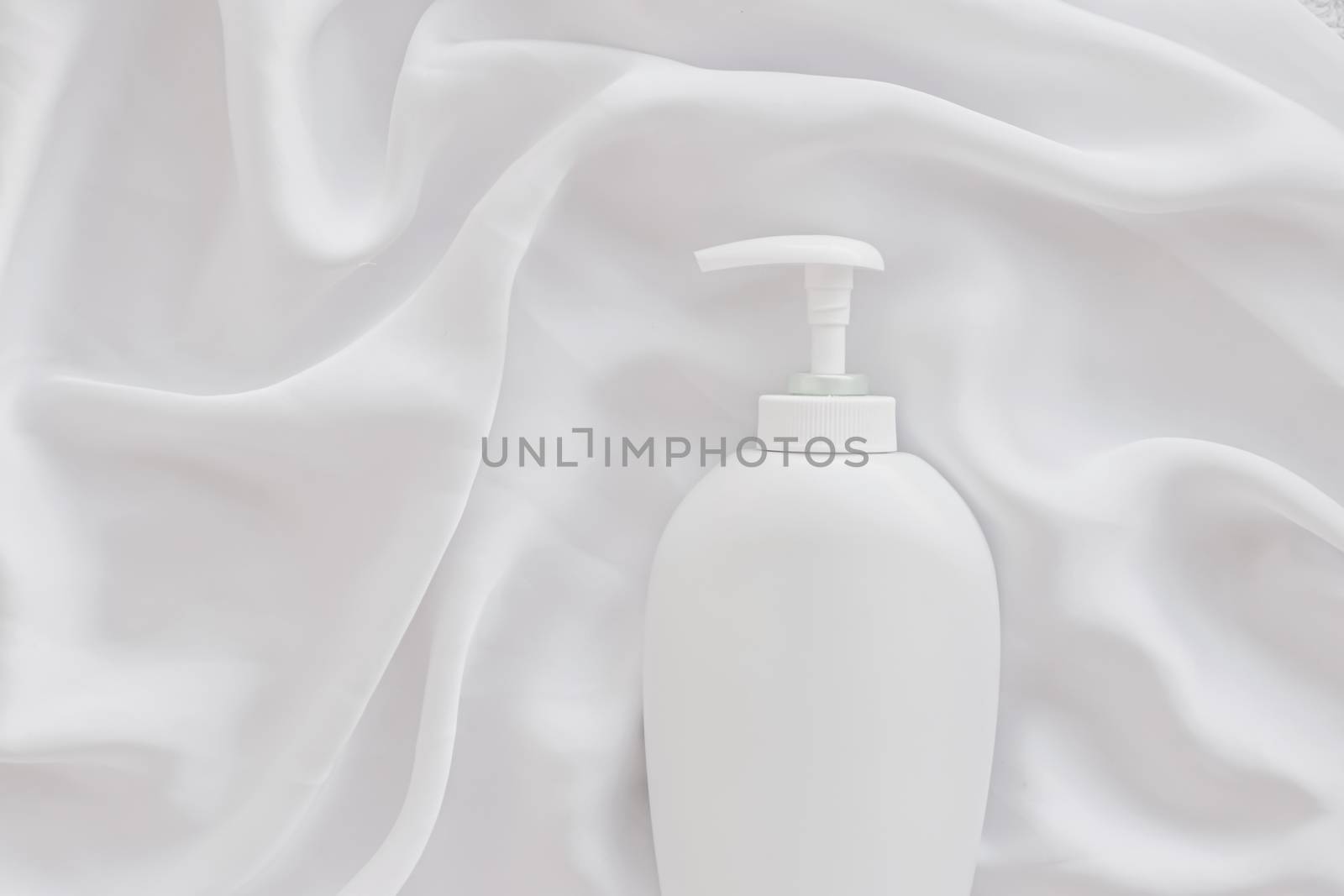 Blank label cosmetic container bottle as product mockup on white silk background, hygiene and healthcare