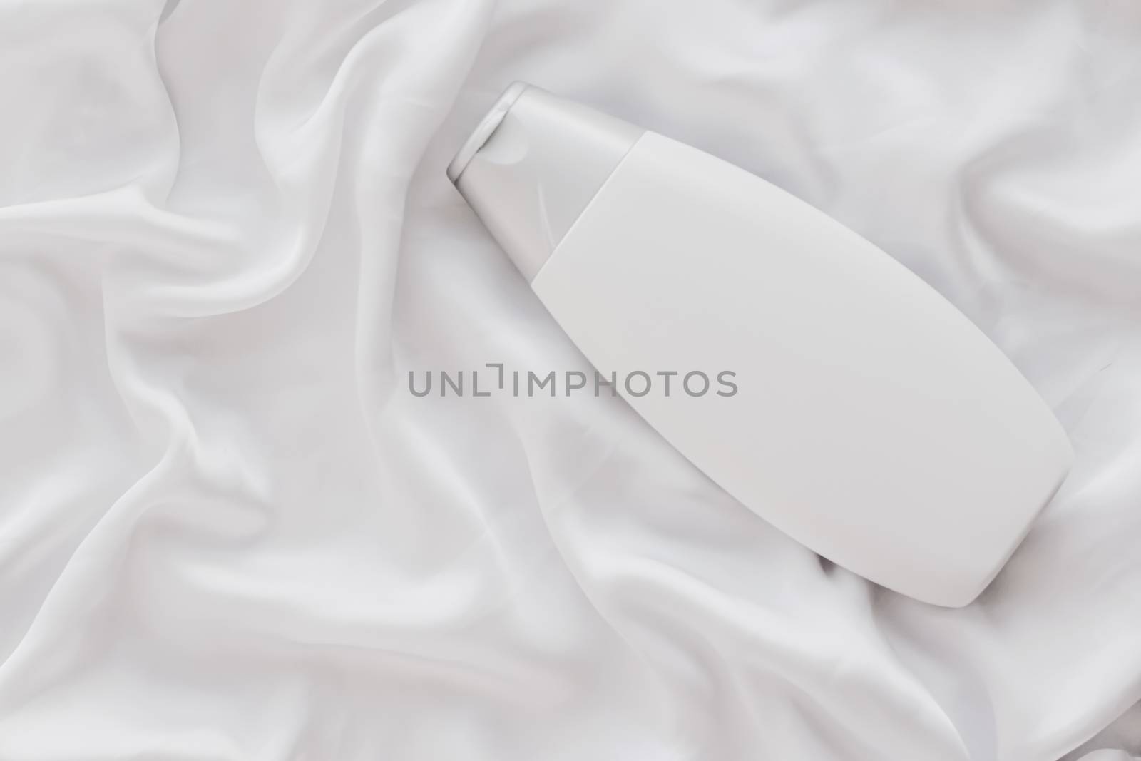 Blank label cosmetic container bottle as product mockup on white silk background, hygiene and healthcare