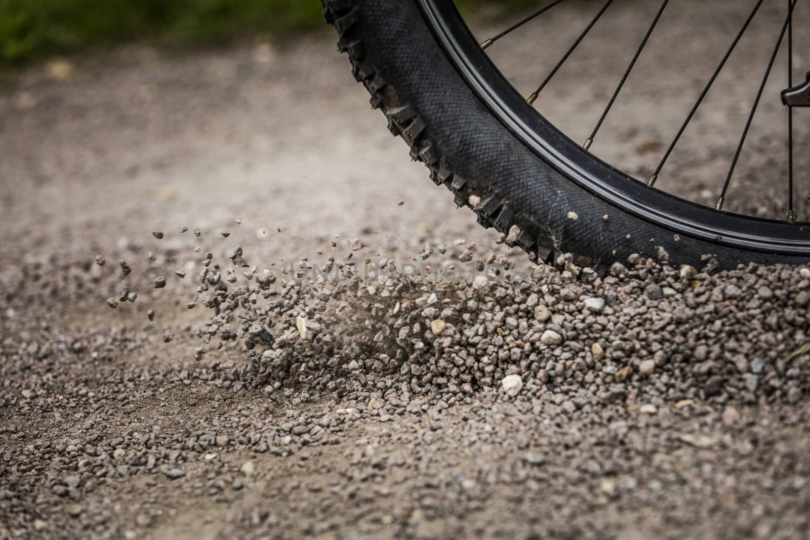 Tealby, Lincolnshire, UK, July 2017, Bike tire kicking up stones by ElectricEggPhoto