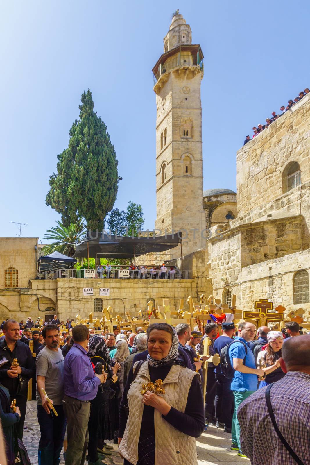 Jerusalem, Israel - April 6, 2018: Orthodox good Friday scene in the entry yard of the church of the holy sepulcher, with pilgrims carrying crosses. The old city of Jerusalem, Israel