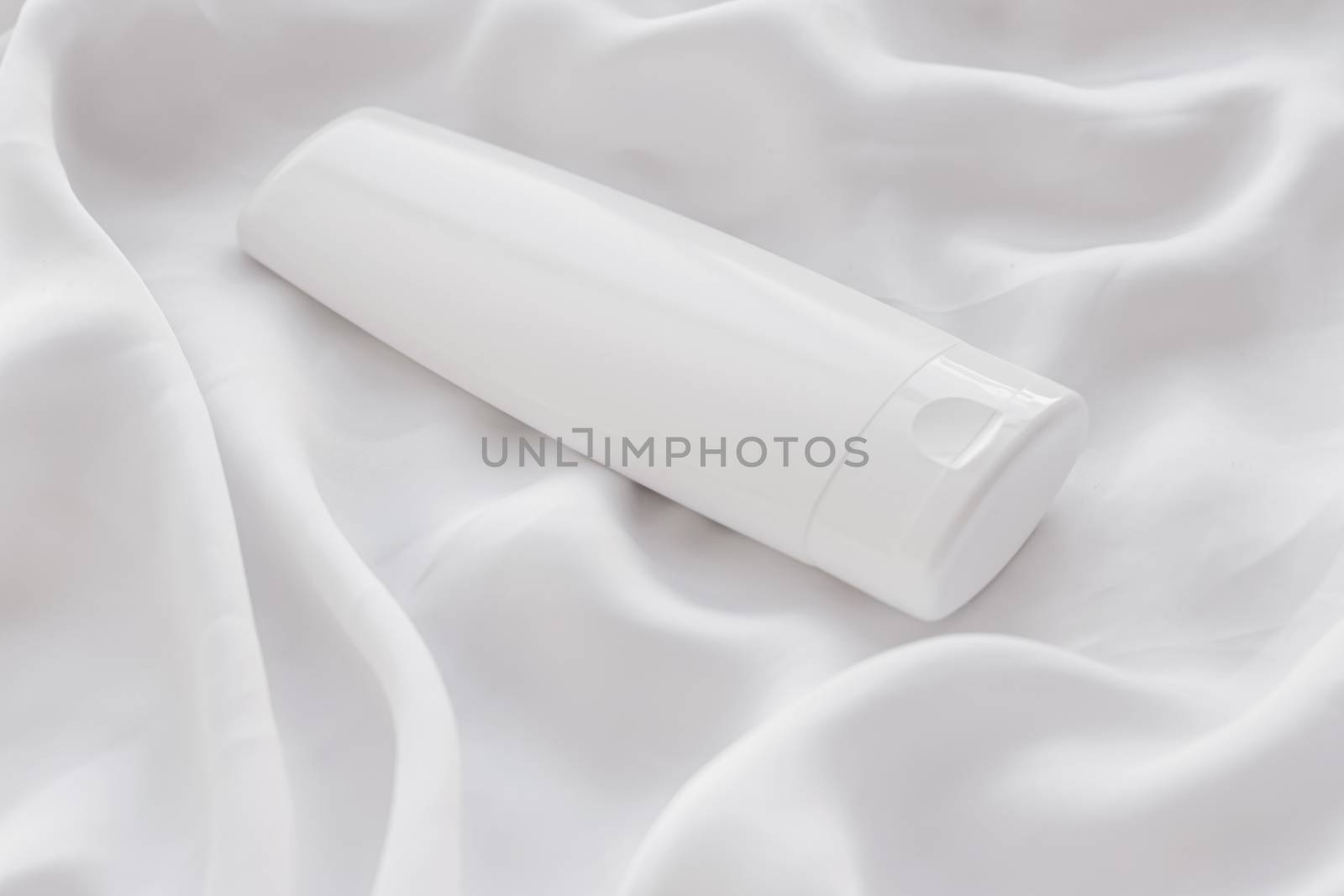 Blank label cosmetic container bottle as product mockup on white silk background, hygiene and healthcare