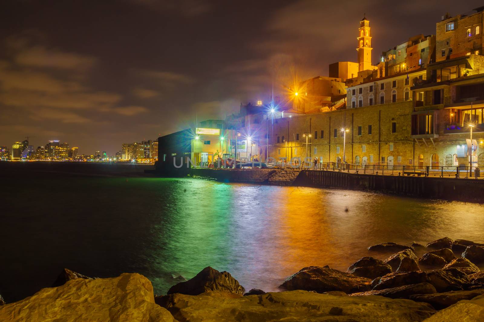 Tel-Aviv, Israel - September 19, 2019: Night scene of the historic Jaffa port, with Saint Peter Church tower, Tel-Aviv skyline, locals and visitors. Now part of Tel-Aviv-Yafo, Israel