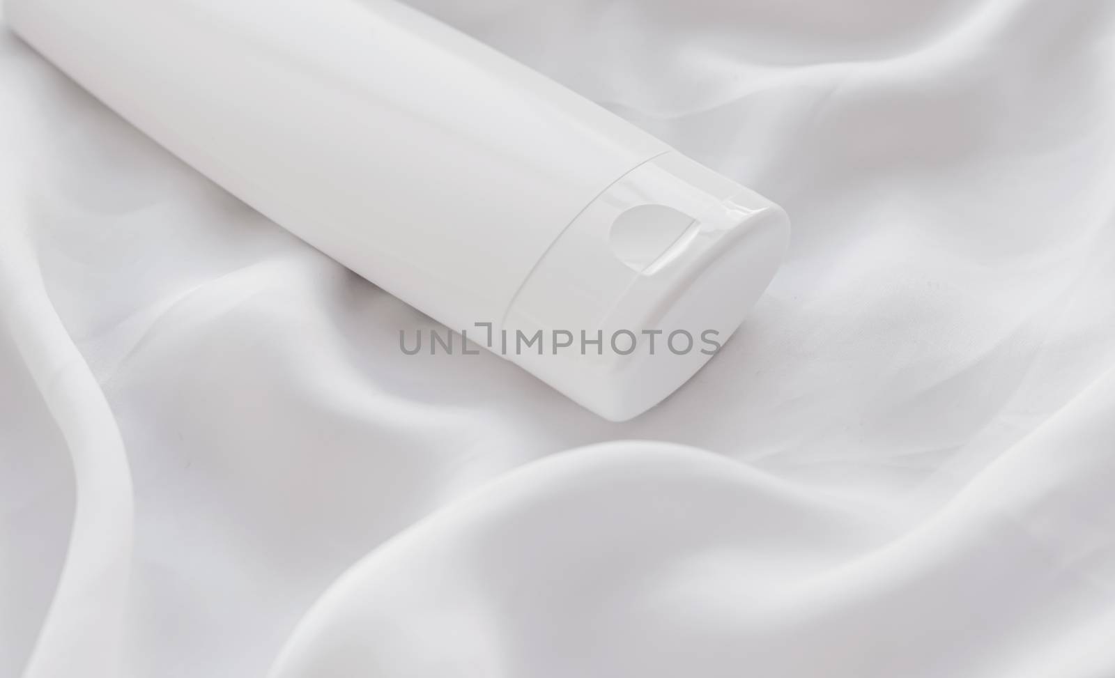 Blank label cosmetic container bottle as product mockup on white silk background, hygiene and healthcare