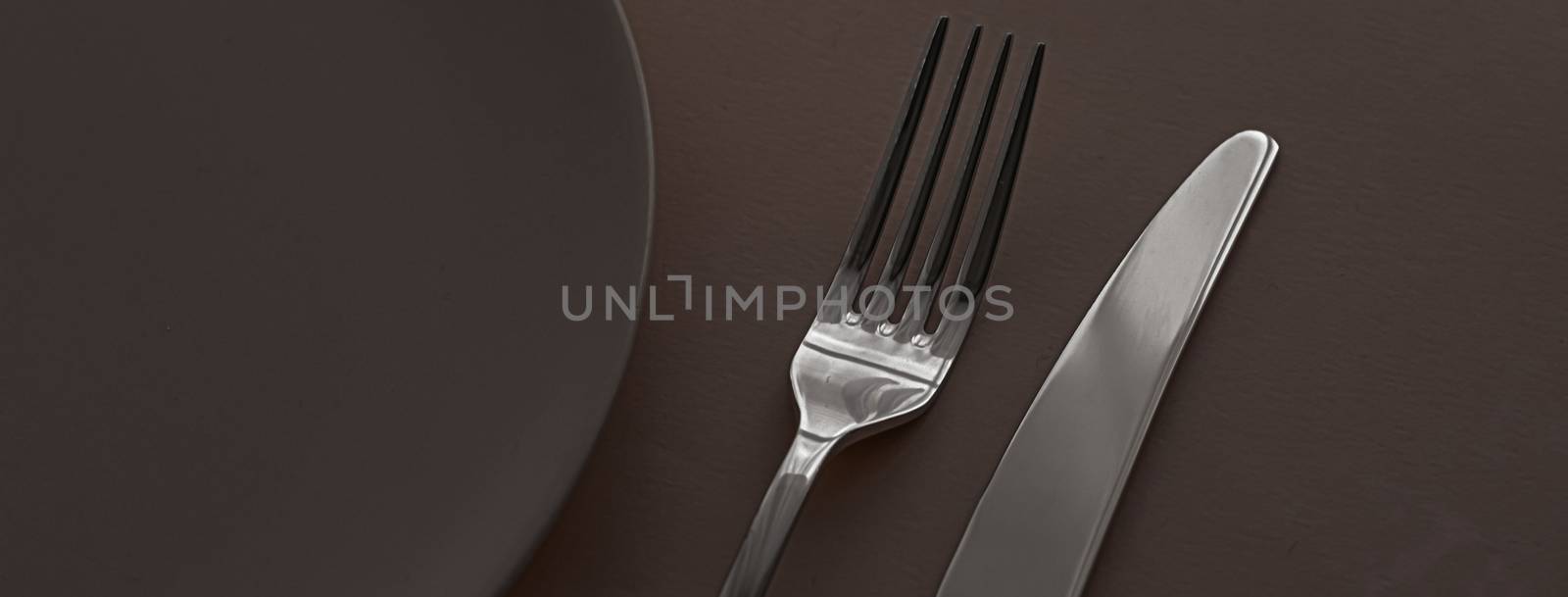 Empty plate and cutlery as mockup set on dark brown background, top tableware for chef table decor and menu branding design