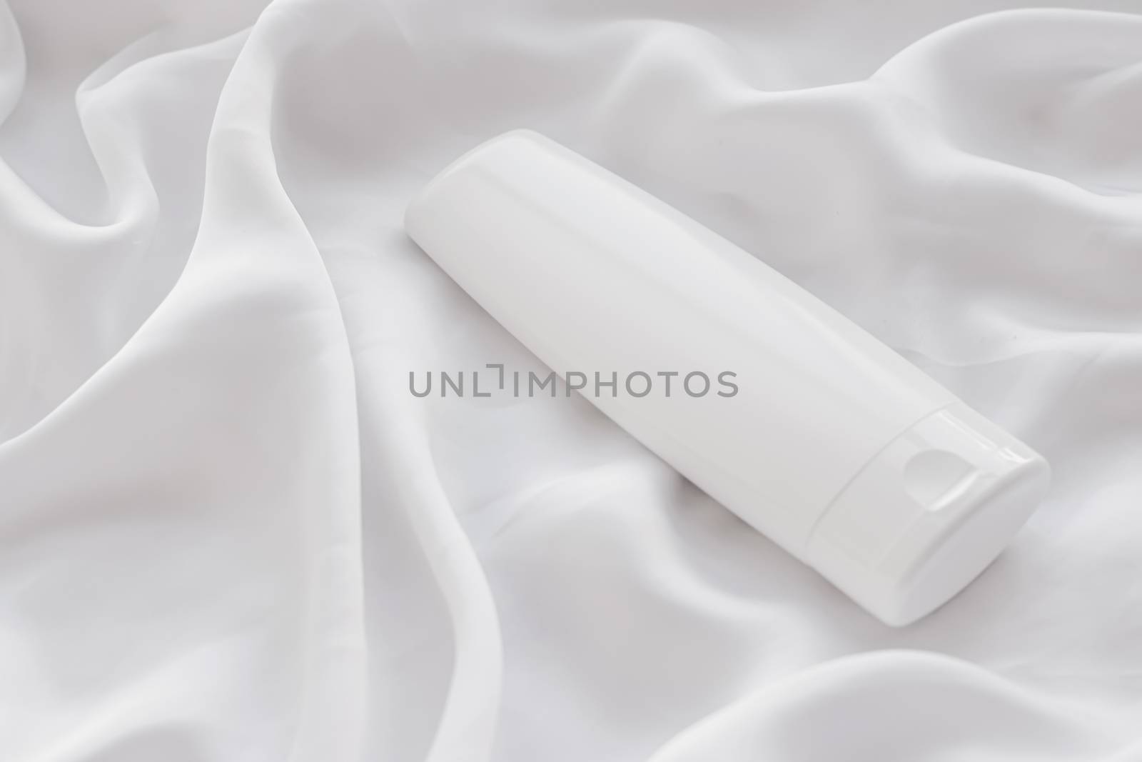 Blank label cosmetic container bottle as product mockup on white silk background, hygiene and healthcare