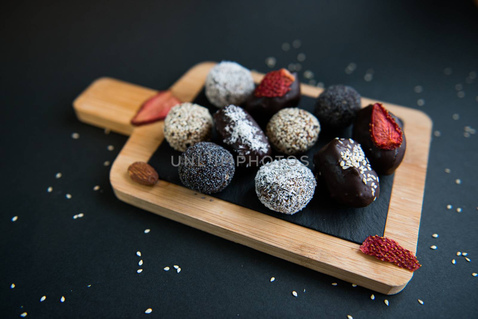 handmade sugar free and gluten free fruit and chocolate candies on a wooden board and black background