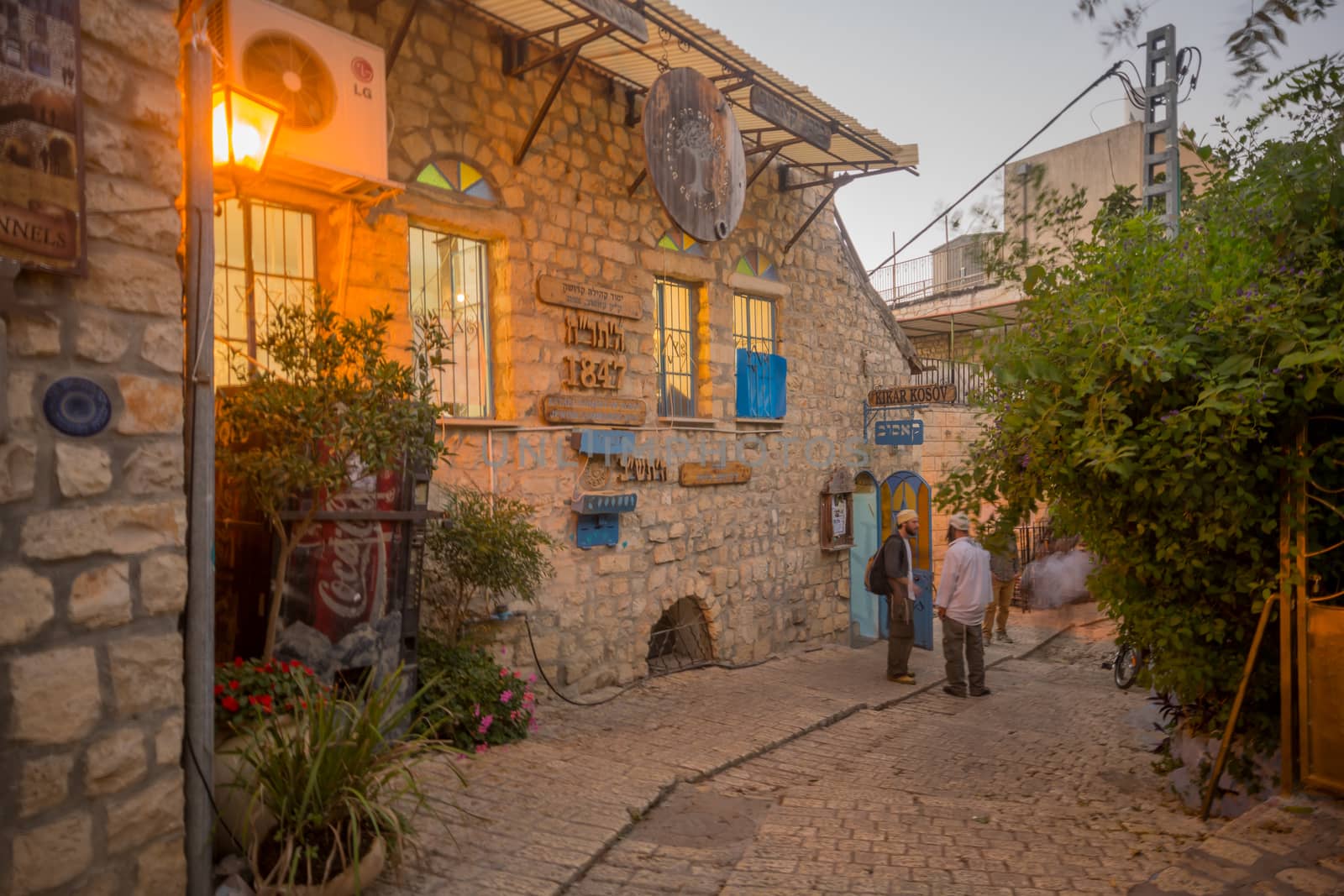 SAFED, ISRAEL - SEPTEMBER 14, 2016: An alley in the Jewish quarter of the old city, at sunset, with various signs, and prayers, in Safed (Tzfat), Israel