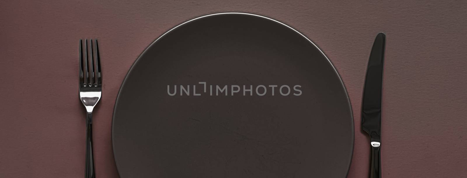 Empty plate and cutlery as mockup set on dark brown background, top tableware for chef table decor and menu branding by Anneleven