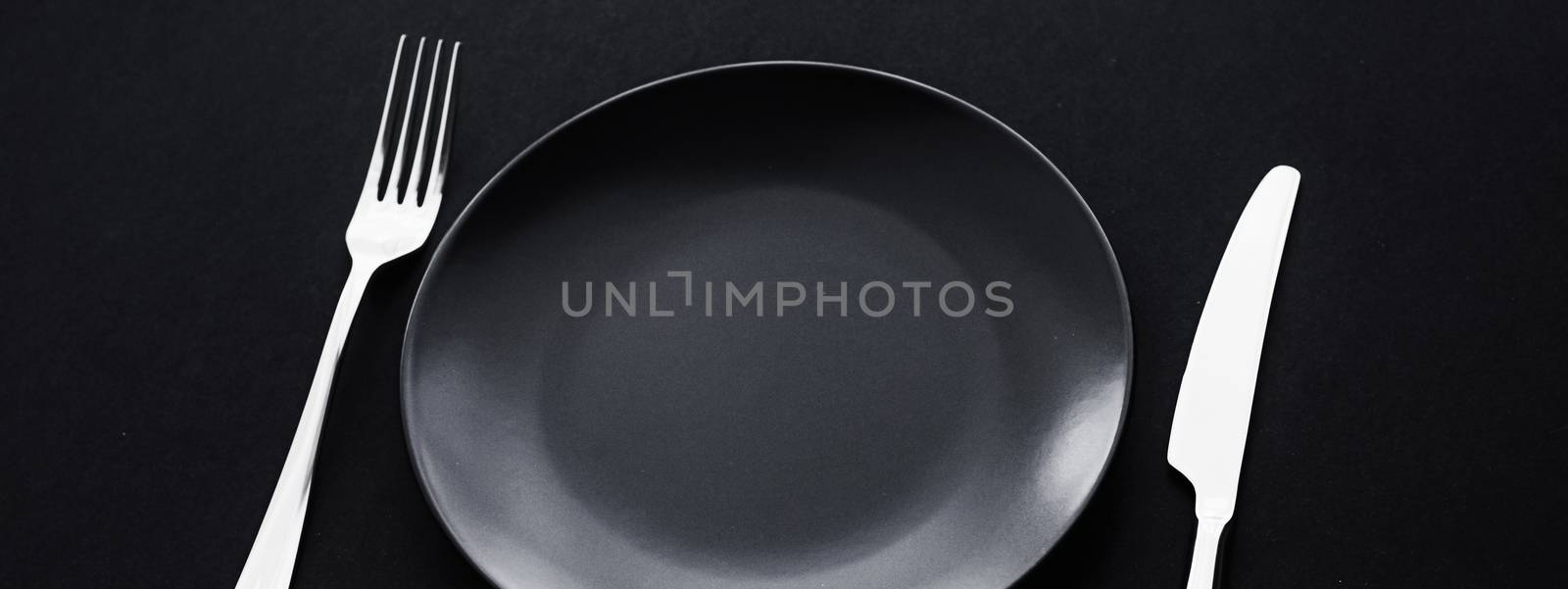 Empty plates and silverware on black background, premium tableware for holiday dinner, minimalistic design and diet concept