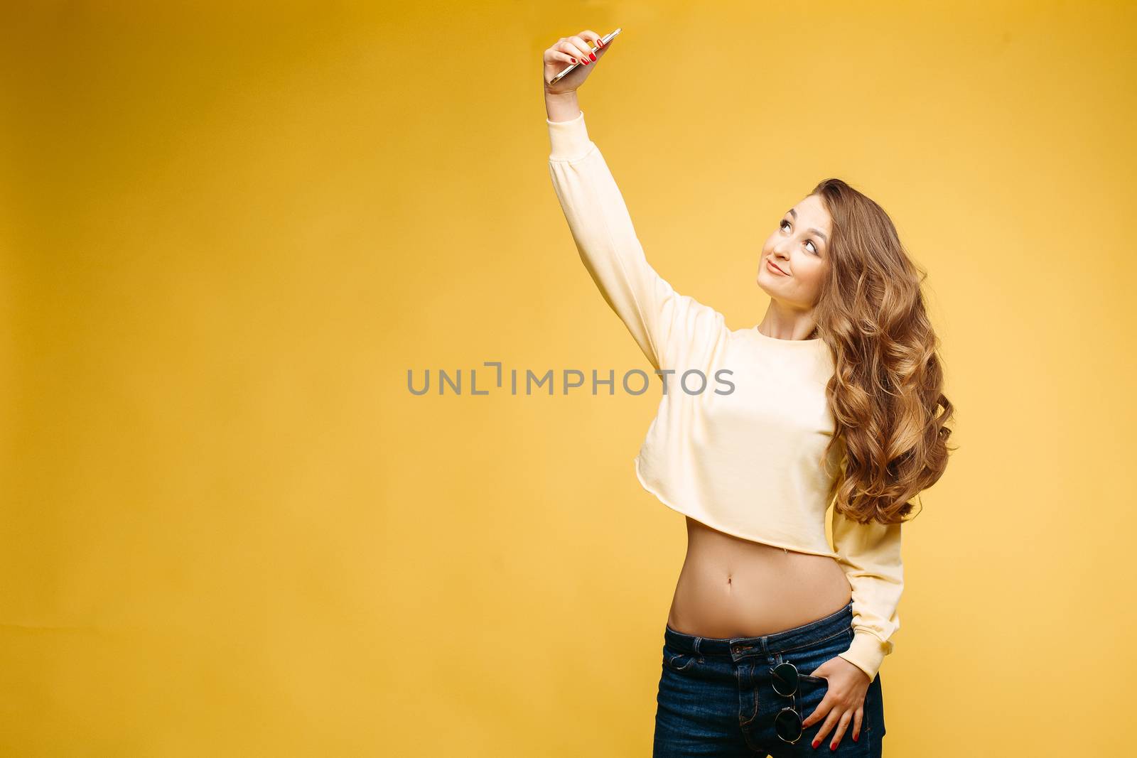 Stylish brunette woman making self portrait at yellow studio. by StudioLucky
