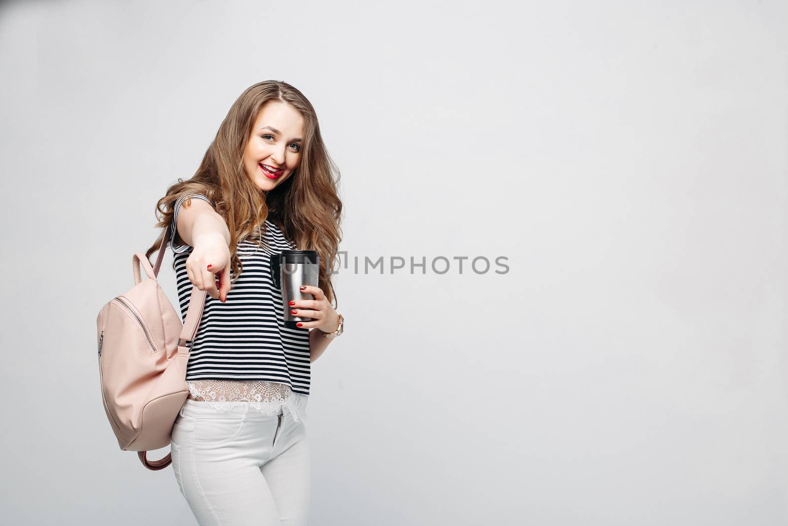 Stylish brunette girl holding thermos with warm coffee. by StudioLucky