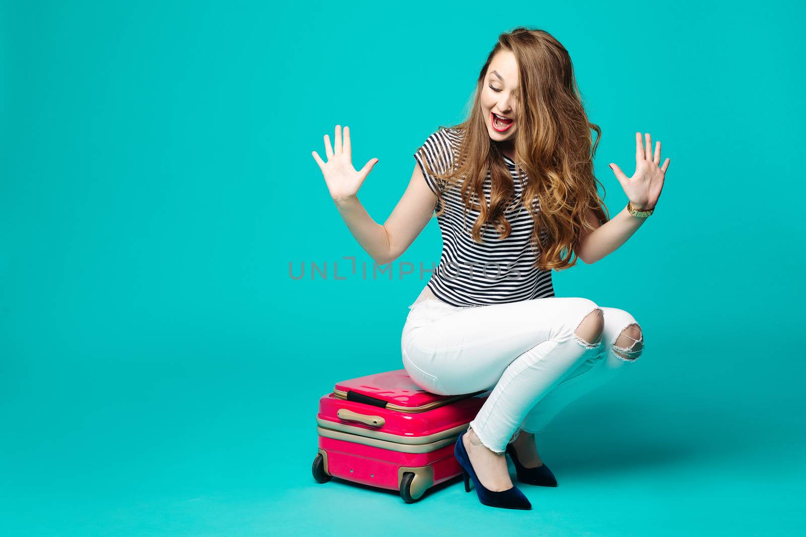 Emotionally girl sitting on travel bag and emotionally gesturing. by StudioLucky