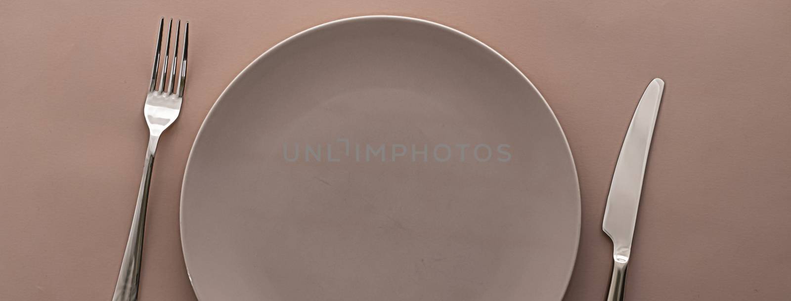 Empty plate and cutlery as mockup set on brown background, top tableware for chef table decor and menu branding by Anneleven