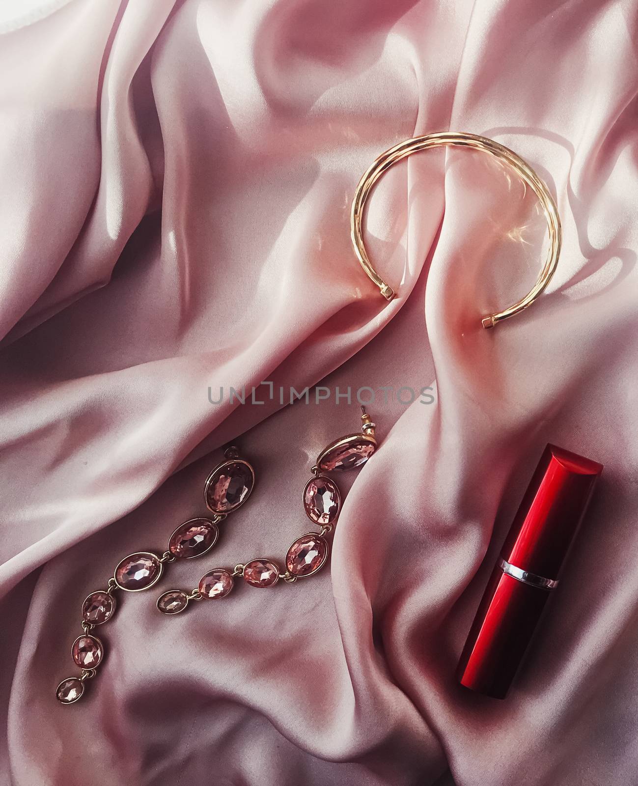 Fashionable and stylish accessories, jewelry and make-up products on pink silk background, beauty and fashion by Anneleven
