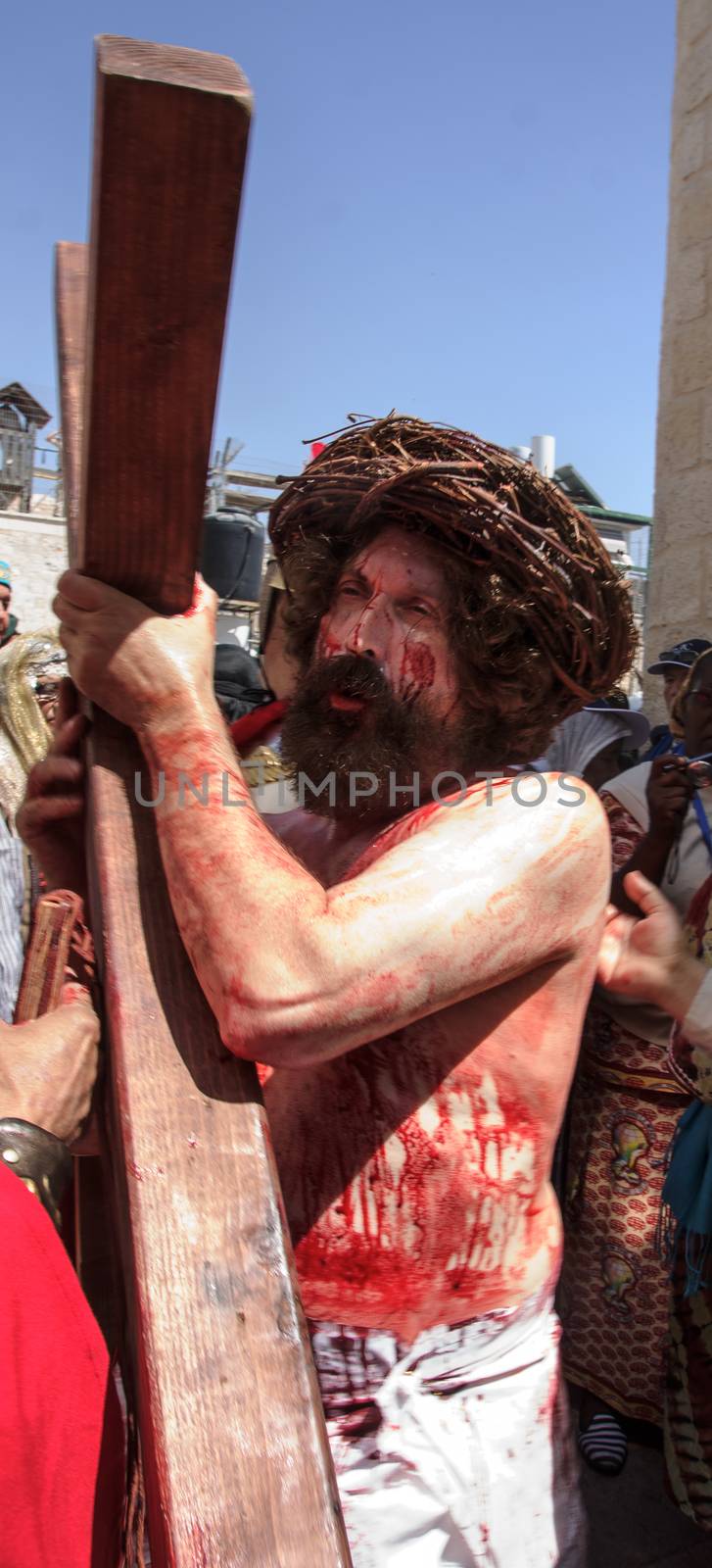 JERUSALEM - APRIL 18, 2014: A group of American actors re-enchant the crucifixion of Jesus Christ along the stations of Via Dolorosa, on Good Friday, in the old city of Jerusalem, Israel