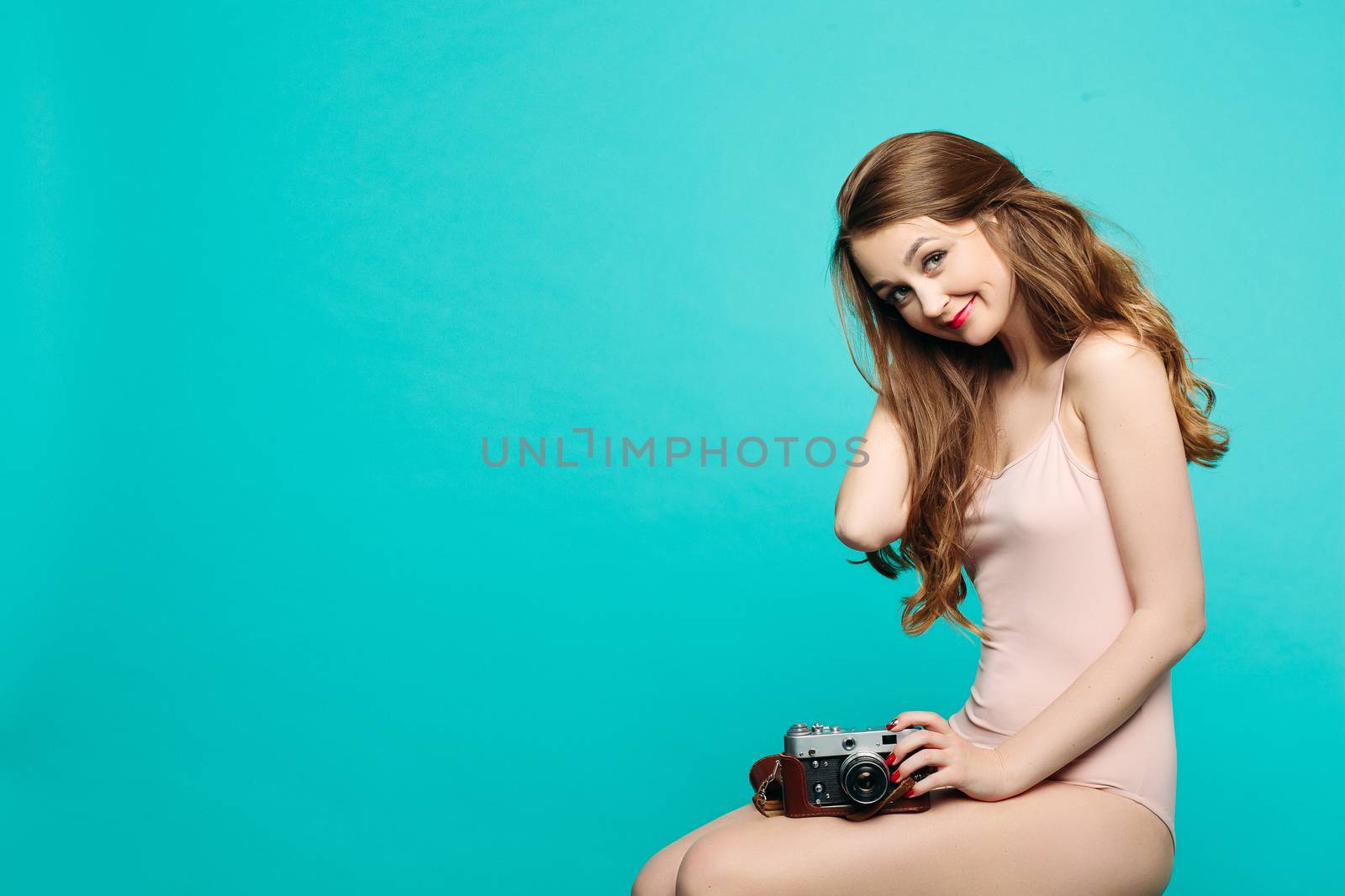 Sexy and beautiful female teacher in dress and eyeglasses, sitting on floor, posing and reading book, gesturing by hands, surprised looking up. Stylish pretty teacher or seductive female student.