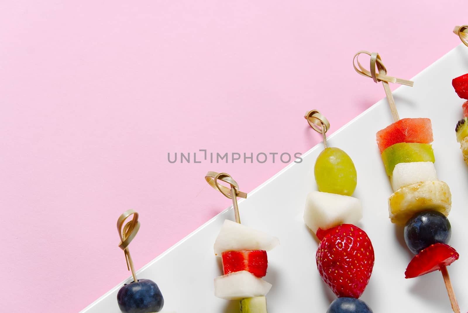 Fruit canapes. Fresh fruit canapes on white plate. Mixed fruit in white plate healthy food style. pink backgrounds. by PhotoTime