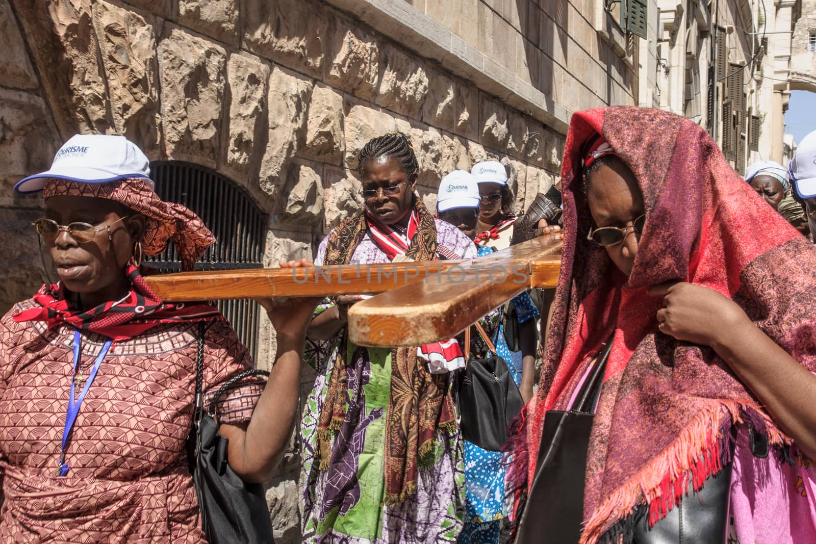 JERUSALEM - APRIL 18, 2014: Pilgrims from all over the world commemorating the crucifixion of Jesus Christ by carrying a cross along via dolorosa, on good Friday, in the old city of Jerusalem, Israel