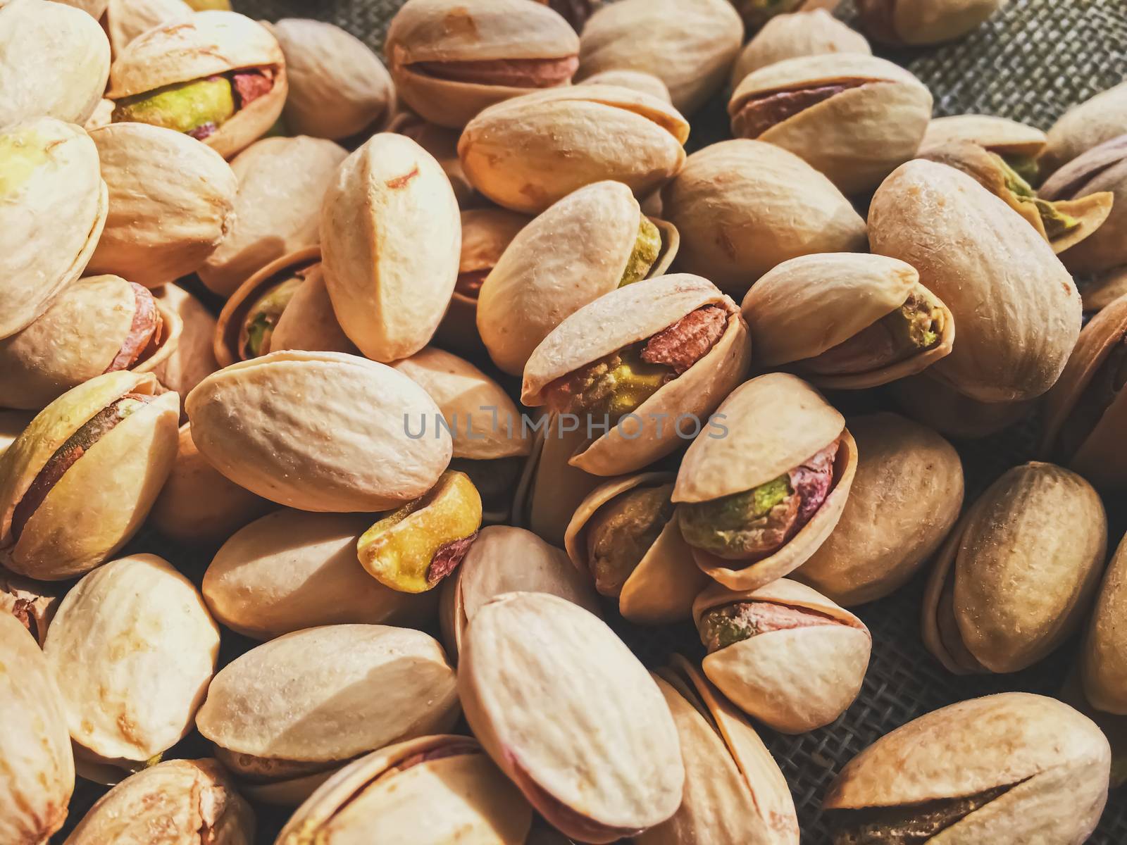 Pistachio nuts on rustic linen background by Anneleven