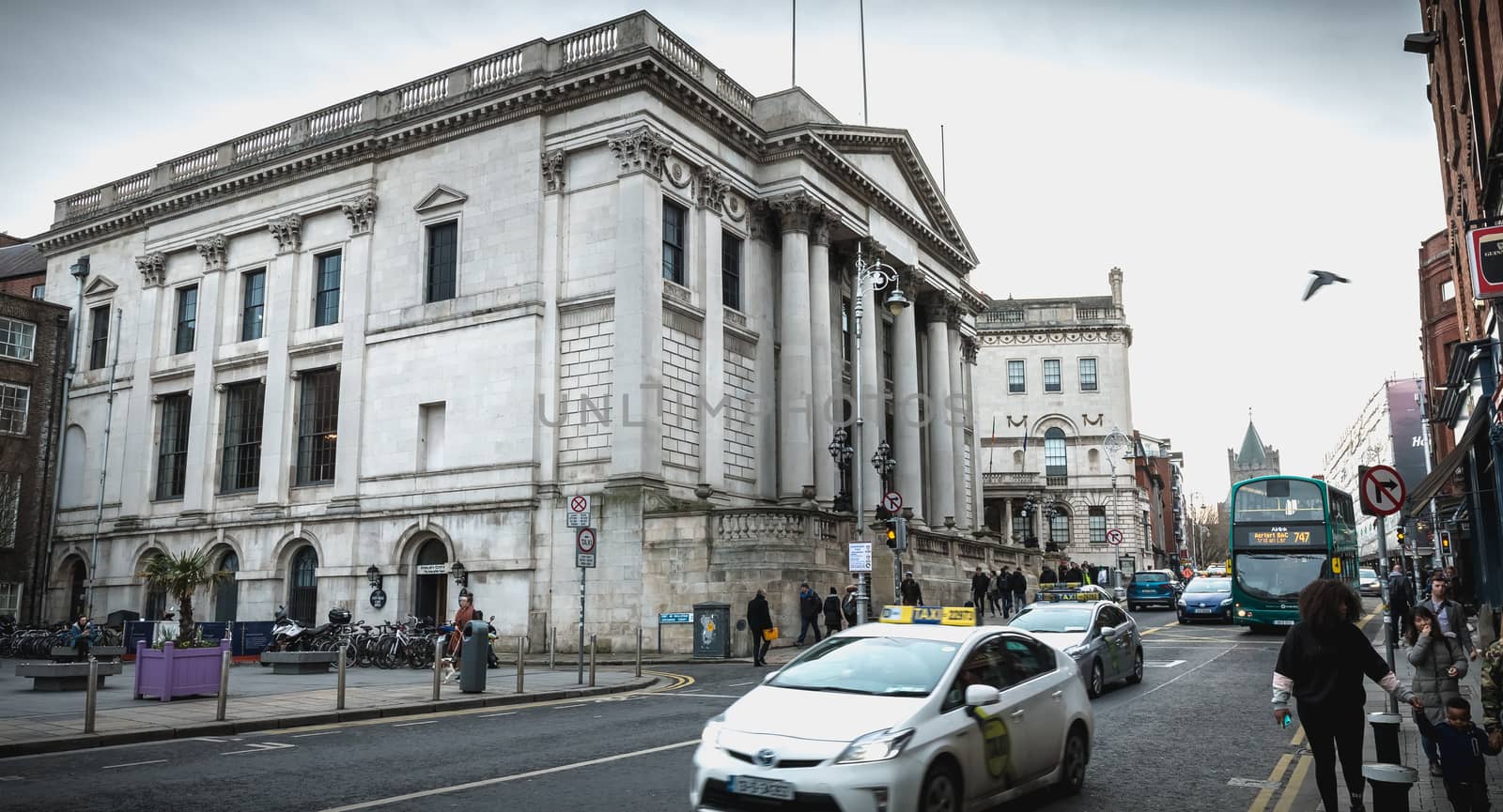 Dublin, Ireland - February 11, 2019: street atmosphere in front of the city hall (Rotunda Hall) with passers-by and cars on a winter day