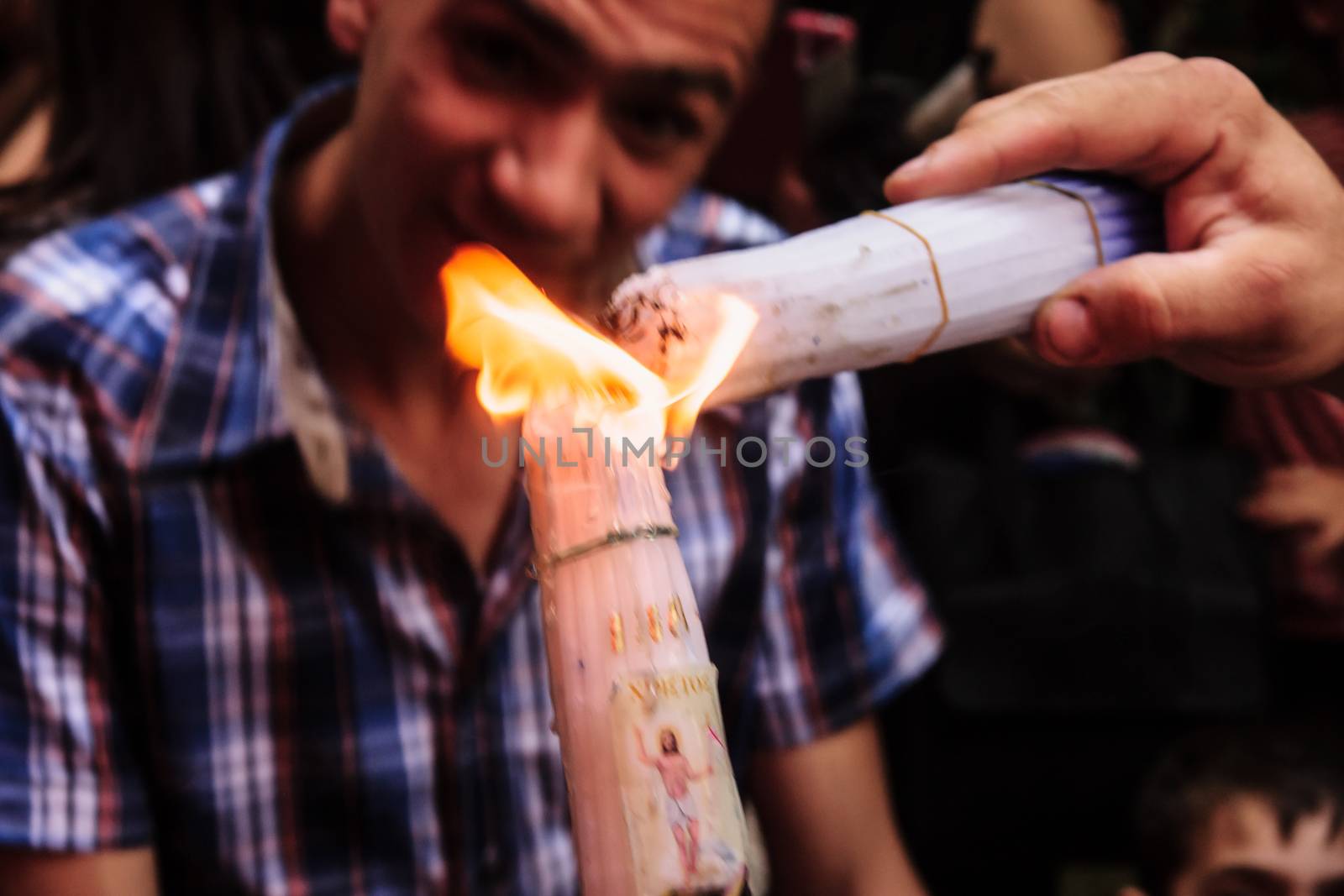 JERUSALEM - APRIL 19, 2014: The holy fire from the holy fire ceremony the Church of the Holy Sepulcher shared between pilgrims along the Via Dolorosa Street, on Holy Saturday, in Jerusalem, Israel