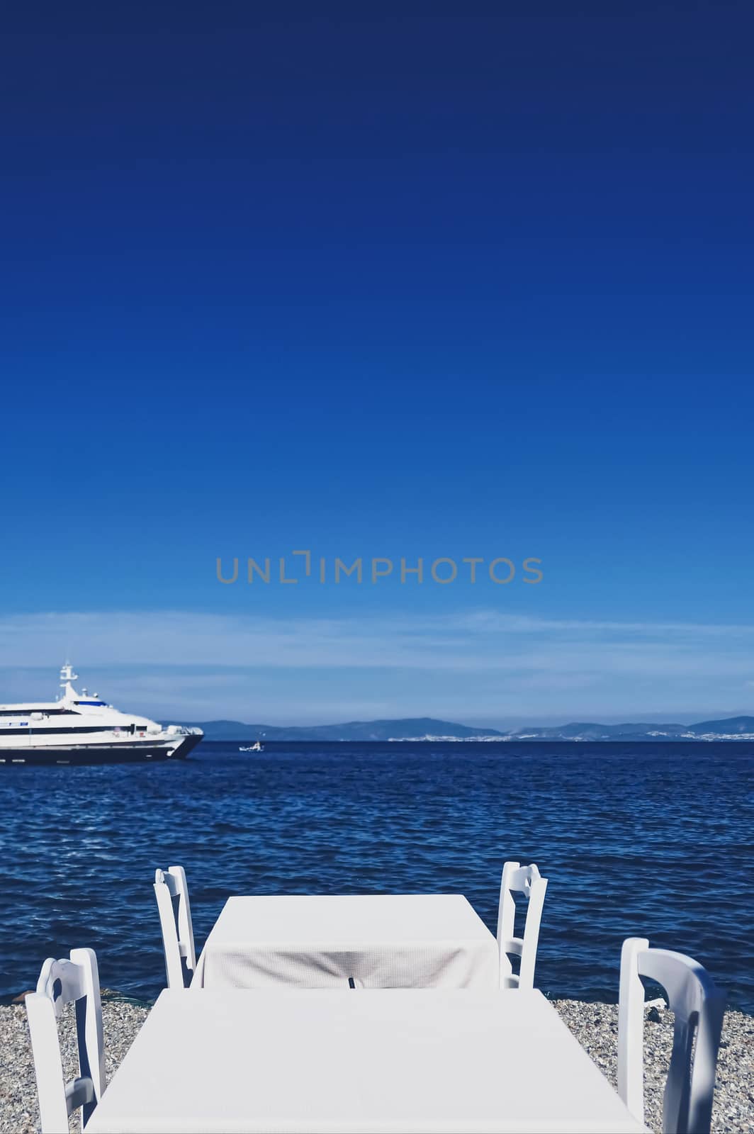 Empty restaurant by the Aegean sea and cruise boat, travel and nature by Anneleven