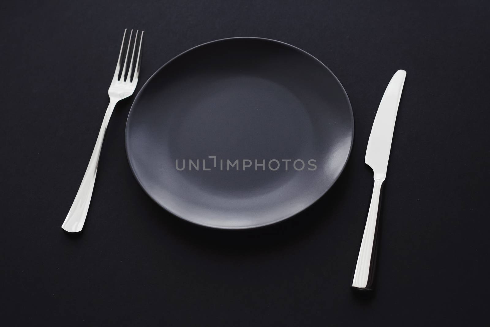 Empty plates and silverware on black background, premium tableware for holiday dinner, minimalistic design and diet by Anneleven