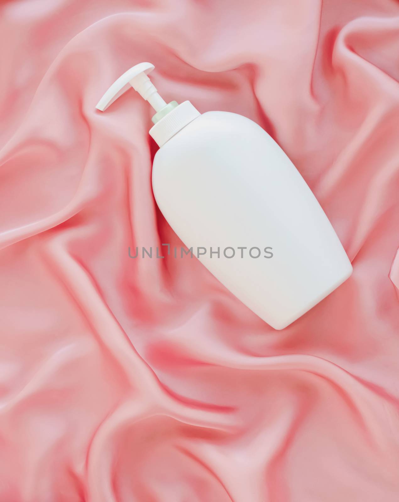 Blank label cosmetic container bottle as product mockup on pink silk background, hygiene and healthcare