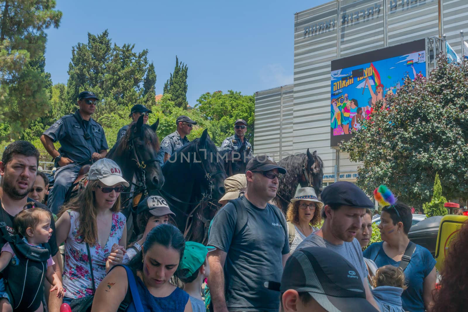 HAIFA, ISRAEL - JUNE 22, 2018: Various people take part, escorted by policemen on horses, in the annual pride parade of the LGBT community, in Haifa, Israel