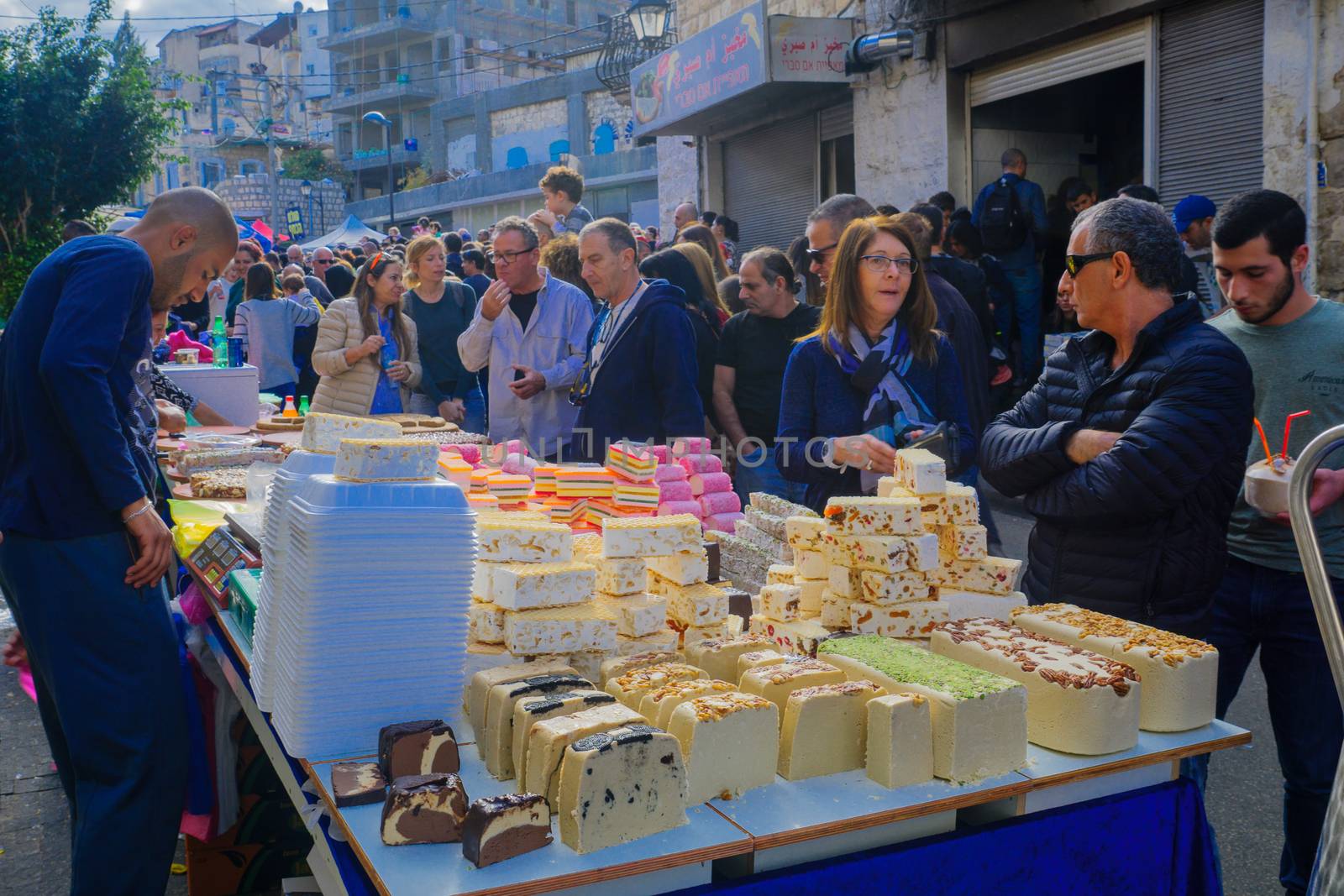 HAIFA, ISRAEL - DECEMBER 10, 2016: Market scene with sellers, shoppers and oriental sweets, as part of the holiday of holidays  events, in Haifa, Israel