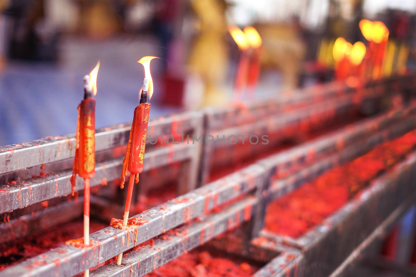 Burning red chinese candle in temple at Thailand by Surasak