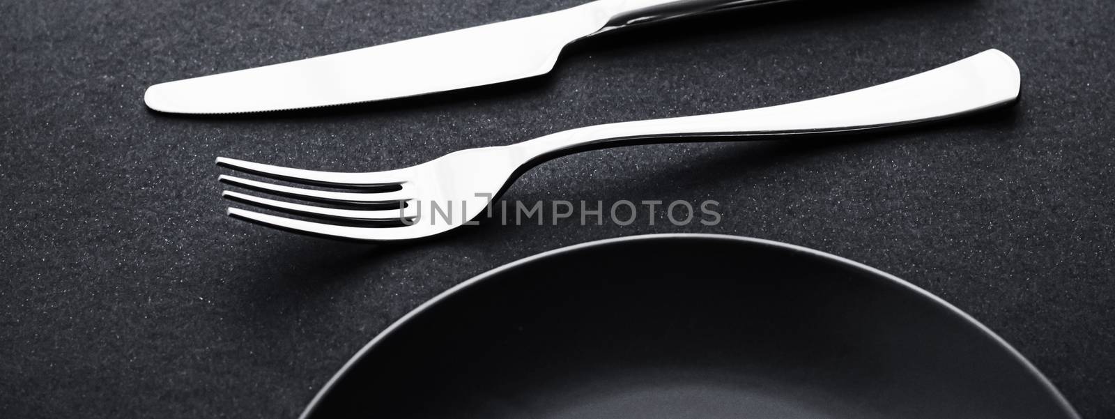 Empty plates and silverware on black background, premium tableware for holiday dinner, minimalistic design and diet concept