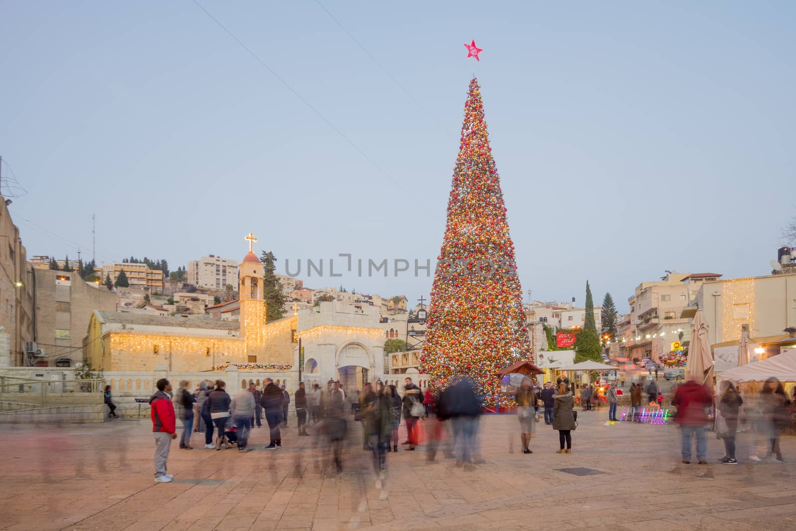 NAZARETH, ISRAEL - DECEMBER 20, 2016: Christmas scene of Mary Well square, with the Greek Orthodox Church of the Annunciation, a Christmas tree, locals and tourists, in Nazareth, Israel